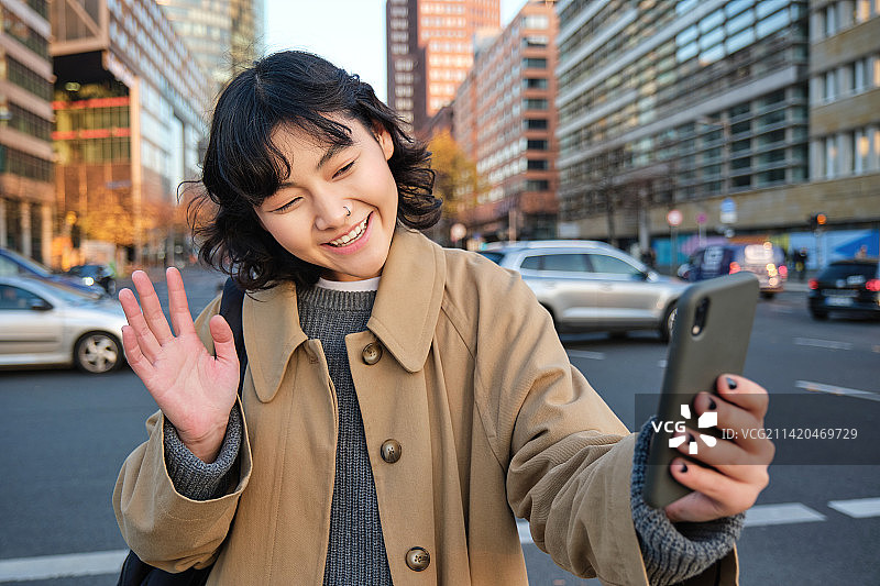 快乐的亚洲女孩游客，在市中心自拍，制作视频图片素材