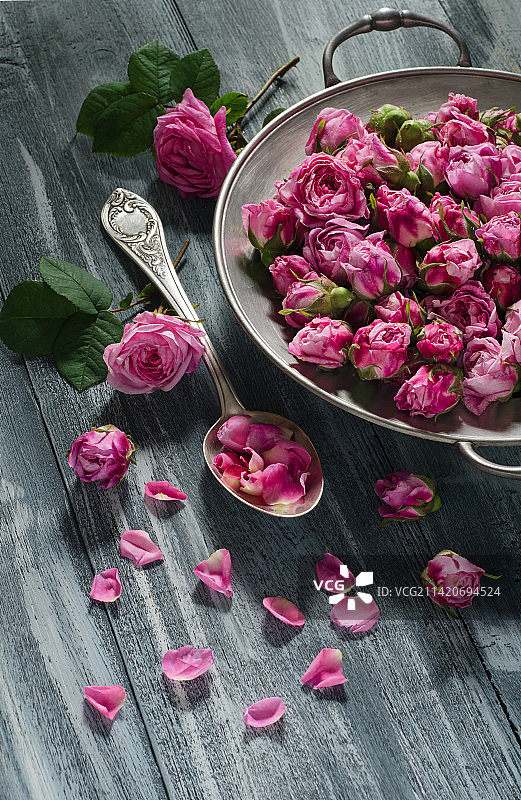 复古盘子和勺子与茶玫瑰花蕾，罗马尼亚图片素材