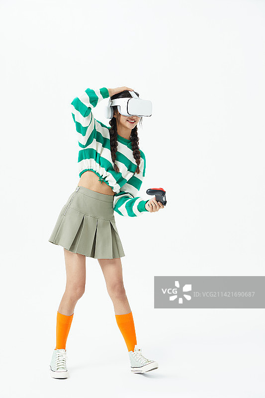 拿着游戏手柄玩VR游戏的年轻女学生图片素材