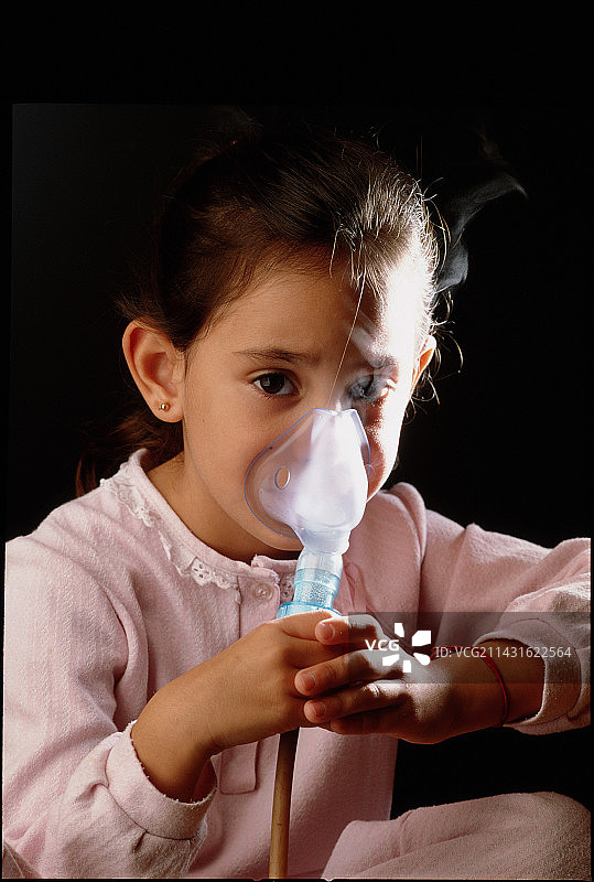 患有哮喘的小女孩用喷雾器呼吸图片素材