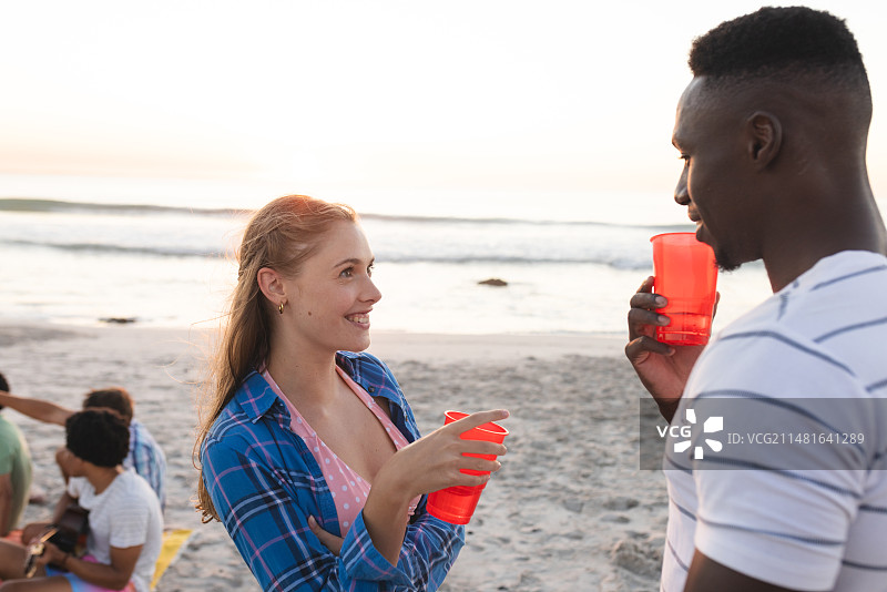 年轻的白人女子和非洲裔美国男子在享受海滩派对图片素材