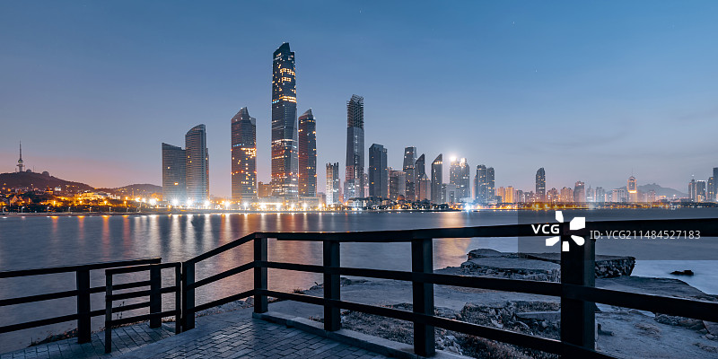 中国山东青岛浮山湾建筑群和海边步行栈道夜景图片素材
