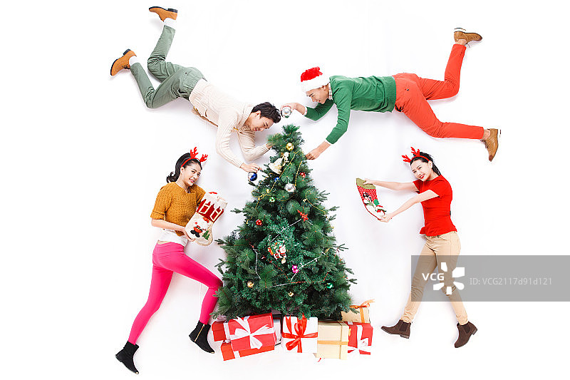 四个青年男女正在装饰圣诞树图片素材