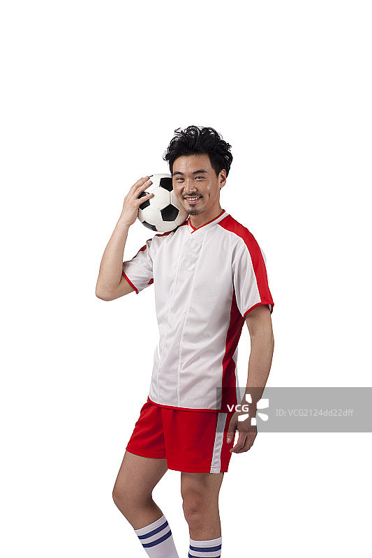 一个穿足球队服玩足球的男青年图片素材