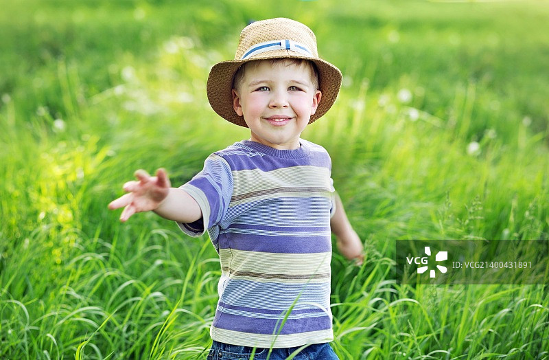 一个可爱的小孩在草地上玩耍的肖像图片素材