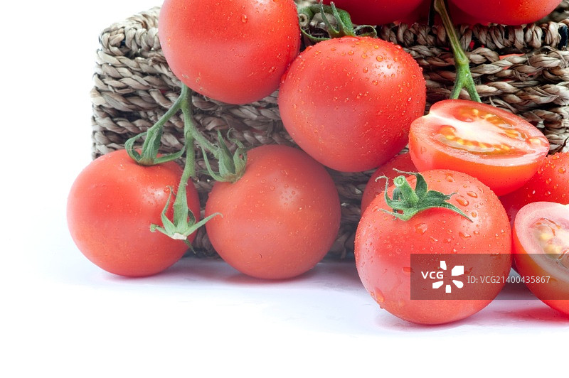 新鲜成熟的藤蕃茄在乡村篮子与切片蕃茄孤立在白色背景图片素材