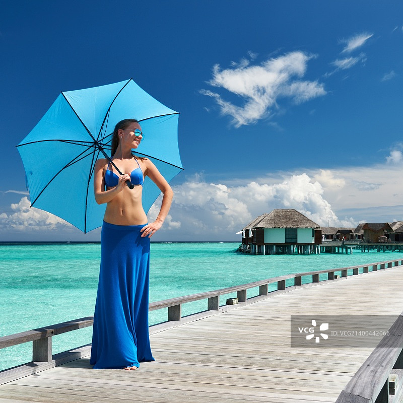在马尔代夫的热带海滩码头上的女人图片素材