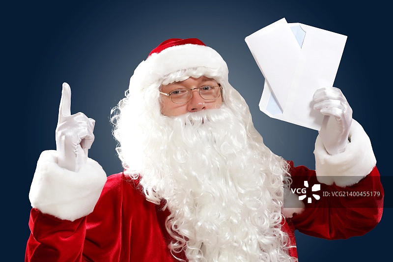圣诞老人拿着并读着给他的信图片素材
