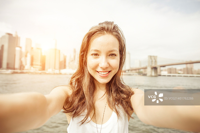 美丽的亚洲女孩拿着相机在纽约自拍图片素材