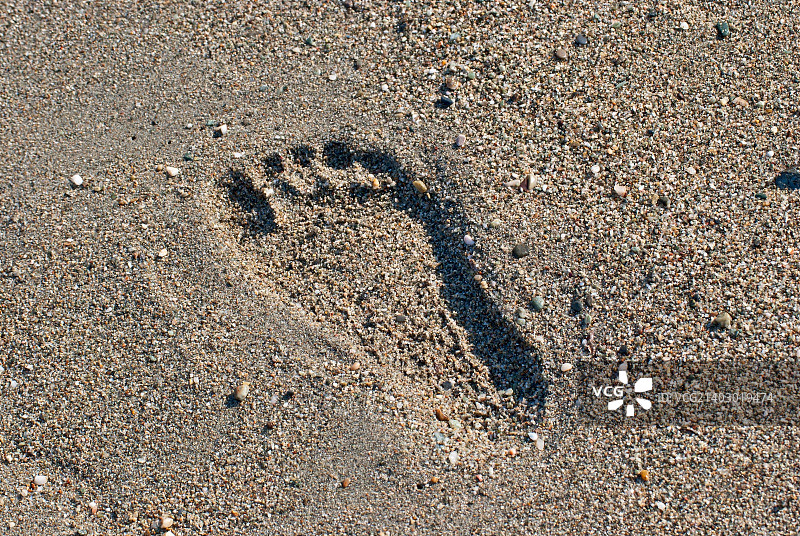 脚印，印在沙滩上的沙子。图片素材