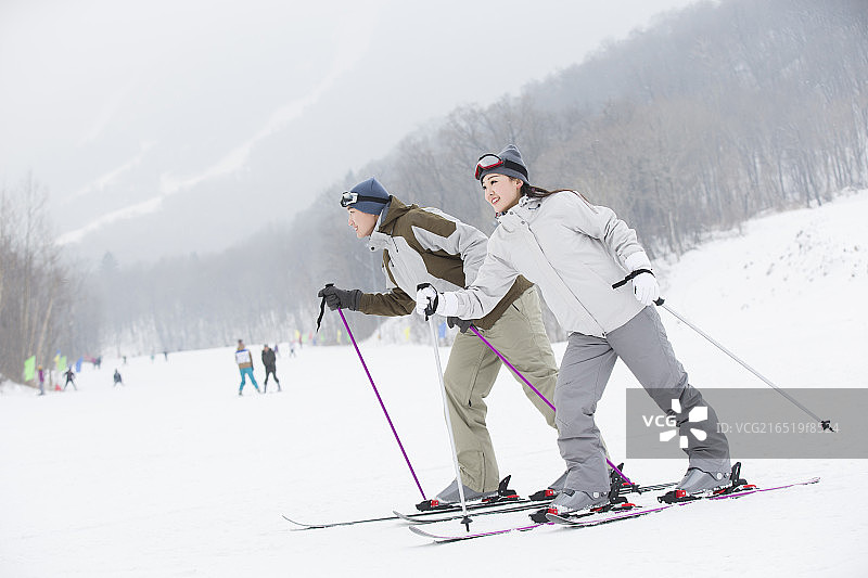年轻情侣在滑雪场滑雪图片素材