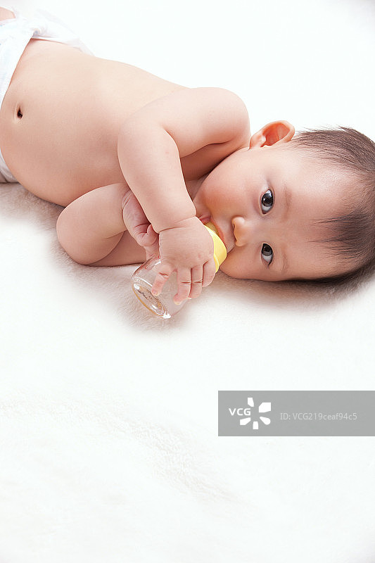 一个婴儿躺着喝奶图片素材