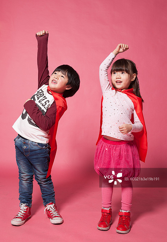 男孩和女孩在模仿超人起飞图片素材