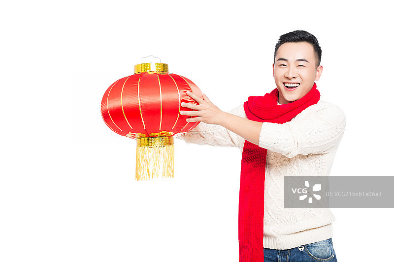 年轻男子手持中国红灯笼庆祝新年图片素材