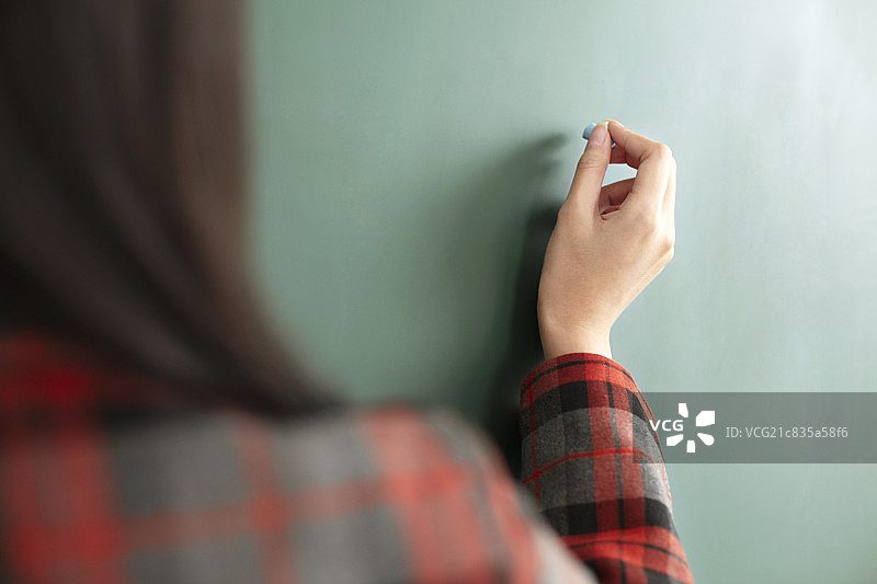 亚洲青年女学生在黑板上写字图片素材