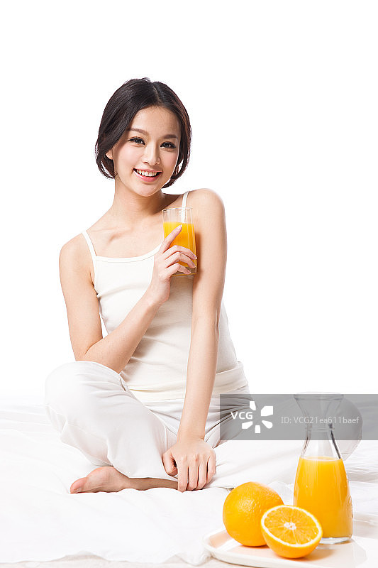 漂亮的青年女人拿着橙汁图片素材