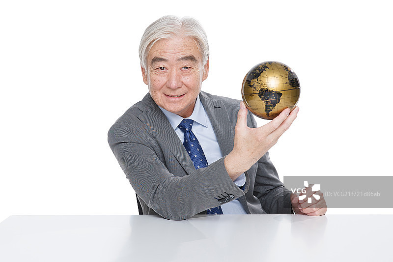 一个成功的商务老年人拿着地球仪图片素材