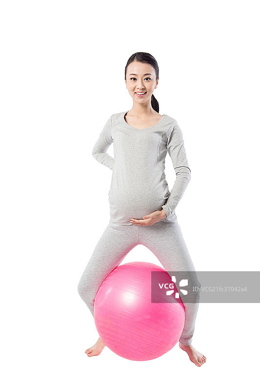 在白色背景下练瑜伽的孕妇图片素材