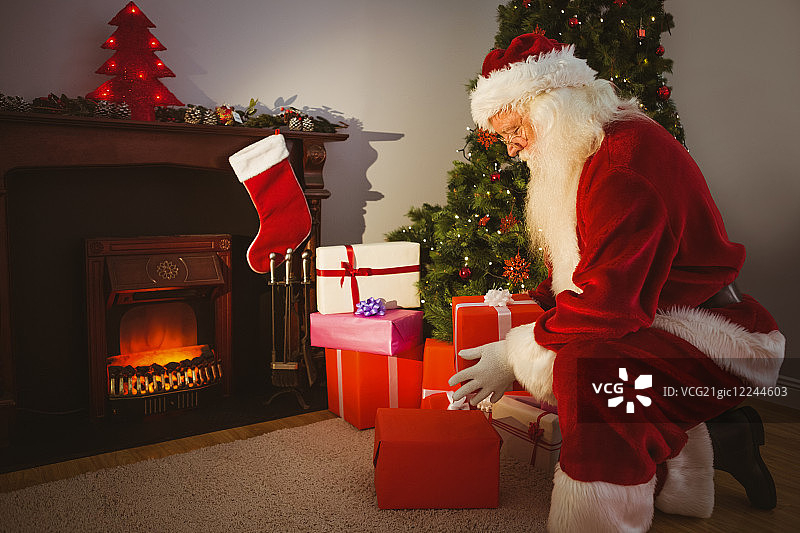 圣诞老人在圣诞前夜在家客厅里分发礼物图片素材