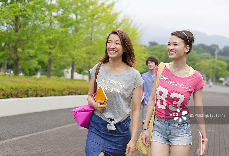 女大学生在校园里的谈话和行走图片素材
