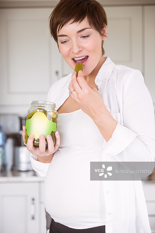孕妇在家厨房吃泡菜罐图片素材