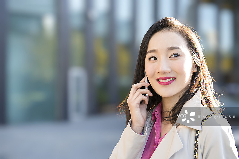 Young businesswoman talking on mobile phone图片素材