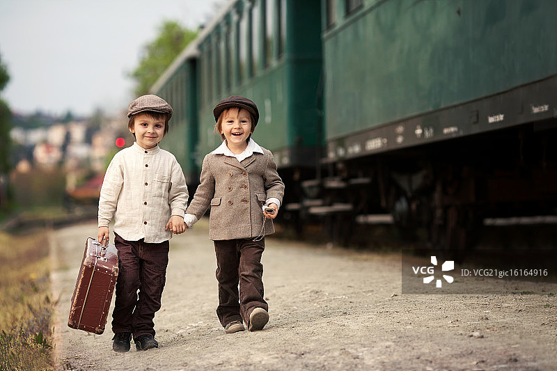 男孩们在火车站散步。图片素材