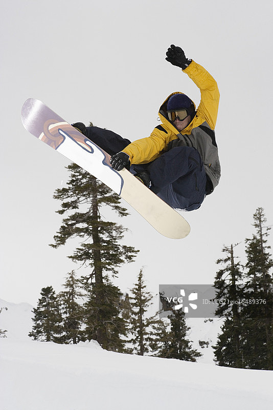 滑雪者在半空中抓住他的滑板图片素材