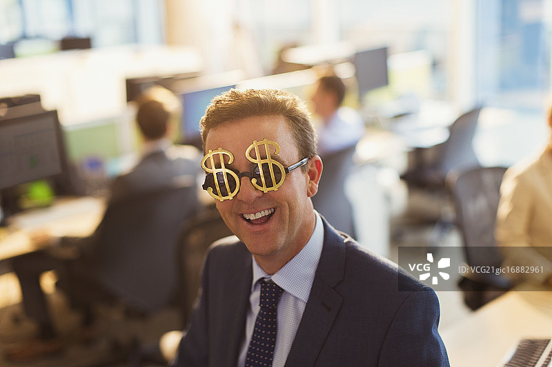 肖像微笑的商人戴着美元标志太阳镜在办公室图片素材