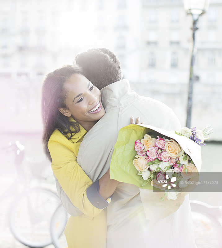 一对情侣在法国巴黎塞纳河上抱着一束鲜花图片素材
