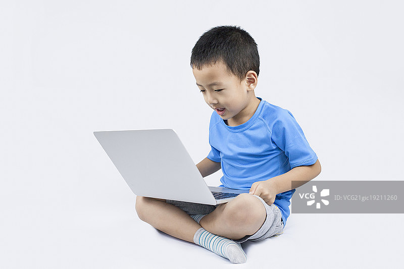 快乐的小男孩使用笔记本电脑图片素材