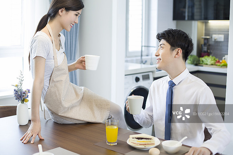 快乐的年轻夫妇在家吃早餐图片素材