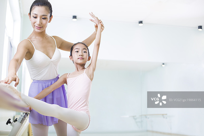 年轻舞蹈老师教小女孩跳芭蕾图片素材