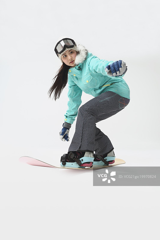 年轻的日本女子穿着滑雪板穿在白色的背景图片素材