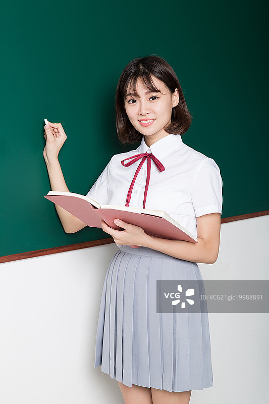 一名漂亮的女高中生站在黑板前图片素材