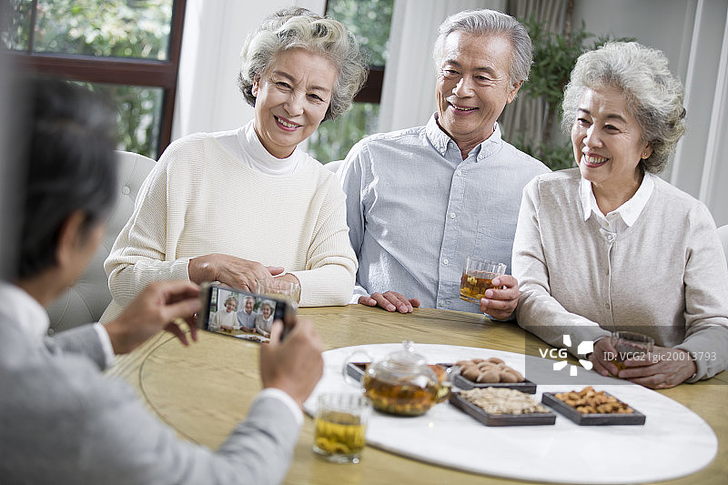 快乐的老年人用手机拍照图片素材