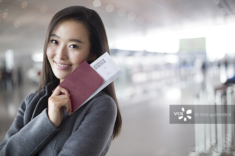 年轻商务女子在机场拿着机票和护照图片素材