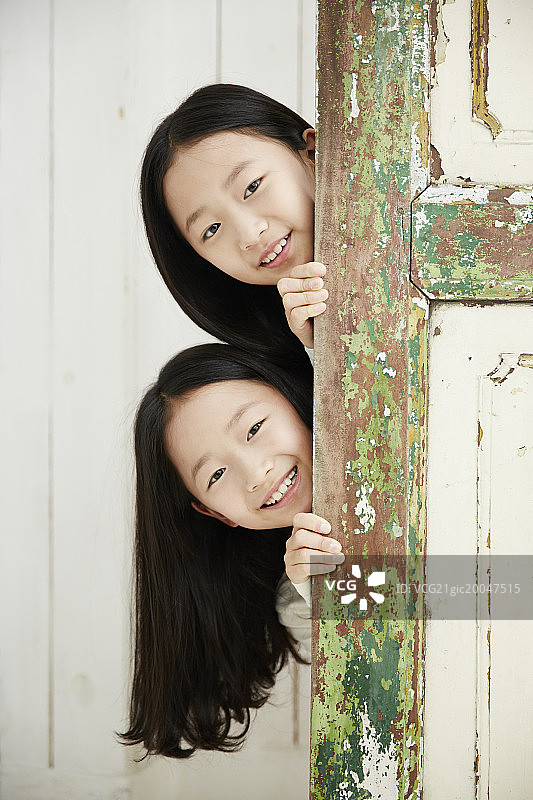 一对双胞胎姐妹在门口张望图片素材
