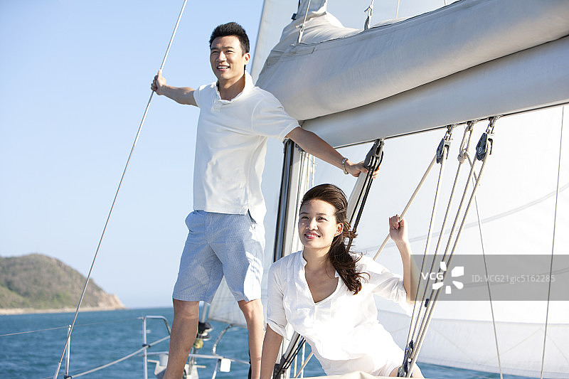 青年夫妇驾帆船航海图片素材