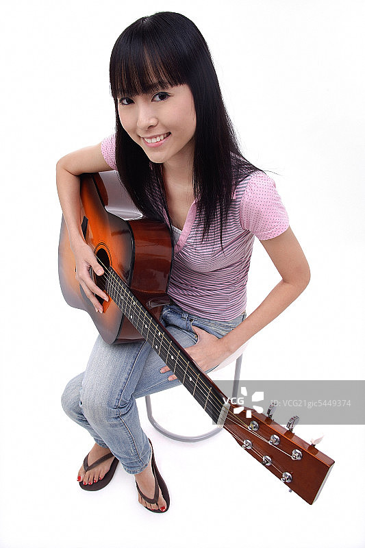 拿着吉他的年轻女子，肖像图片素材