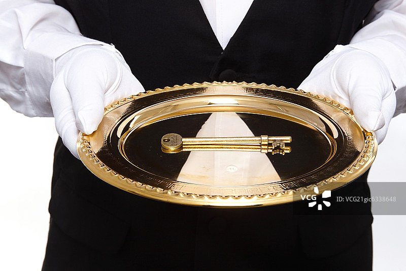 一个男服务生托着金托盘里的金钥匙图片素材