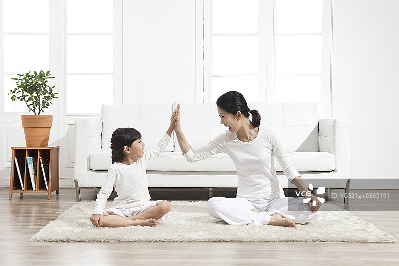 母亲和女儿坐在地毯上图片素材