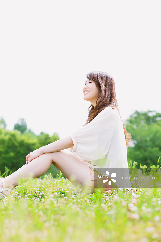 微笑的女人坐在公园里图片素材