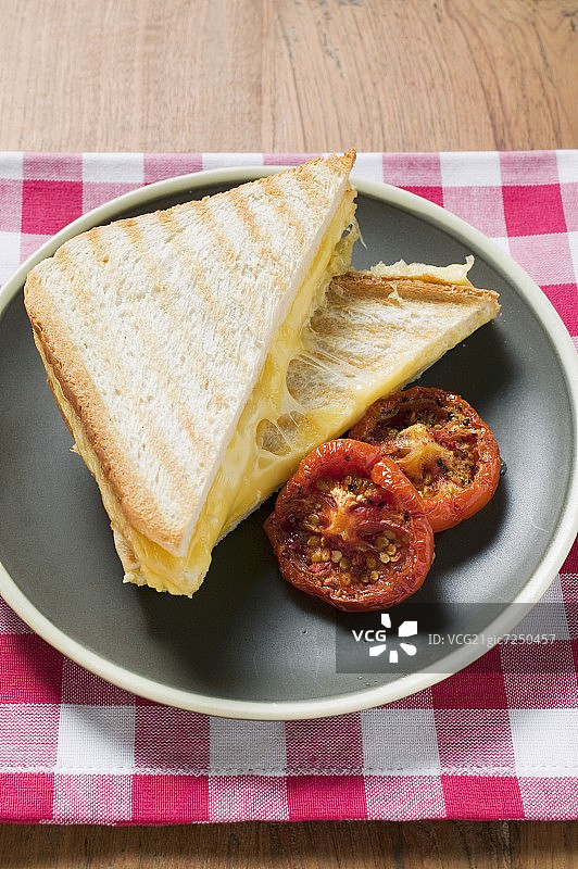 烤奶酪三明治和烤番茄在盘子里图片素材