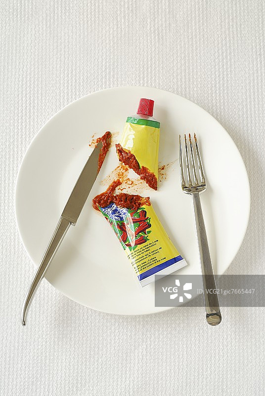 辣椒酱，切成两半，盛在盘子里，用刀叉图片素材