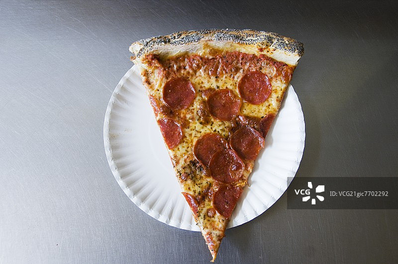在纸盘子上放一片意大利辣香肠披萨;从上面图片素材