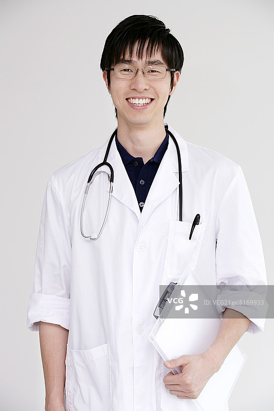 医生穿着实验服和听诊器，面带微笑，画像图片素材