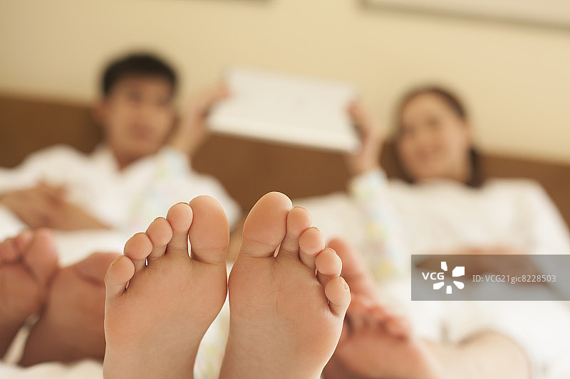 赤脚躺在床上的家人图片素材