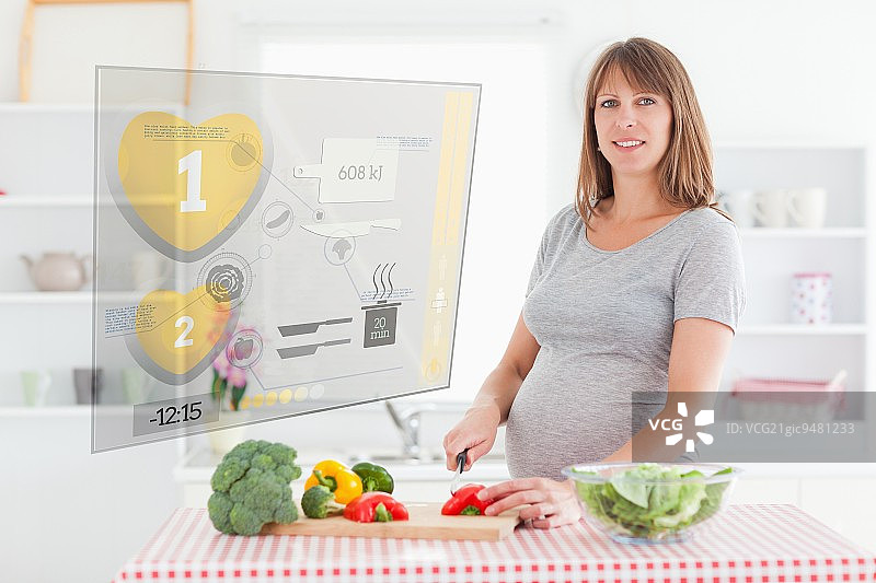 孕妇在厨房用全息界面做晚餐图片素材