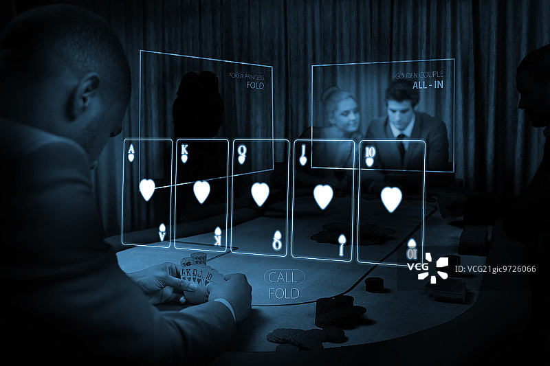 房间的人赌博在桌子上与全息卡显示在蓝色的灯光在黑暗的房间图片素材